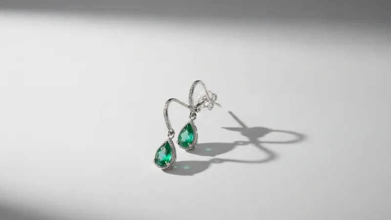 Boucles d'oreilles émeraude et or blanc côte à côte